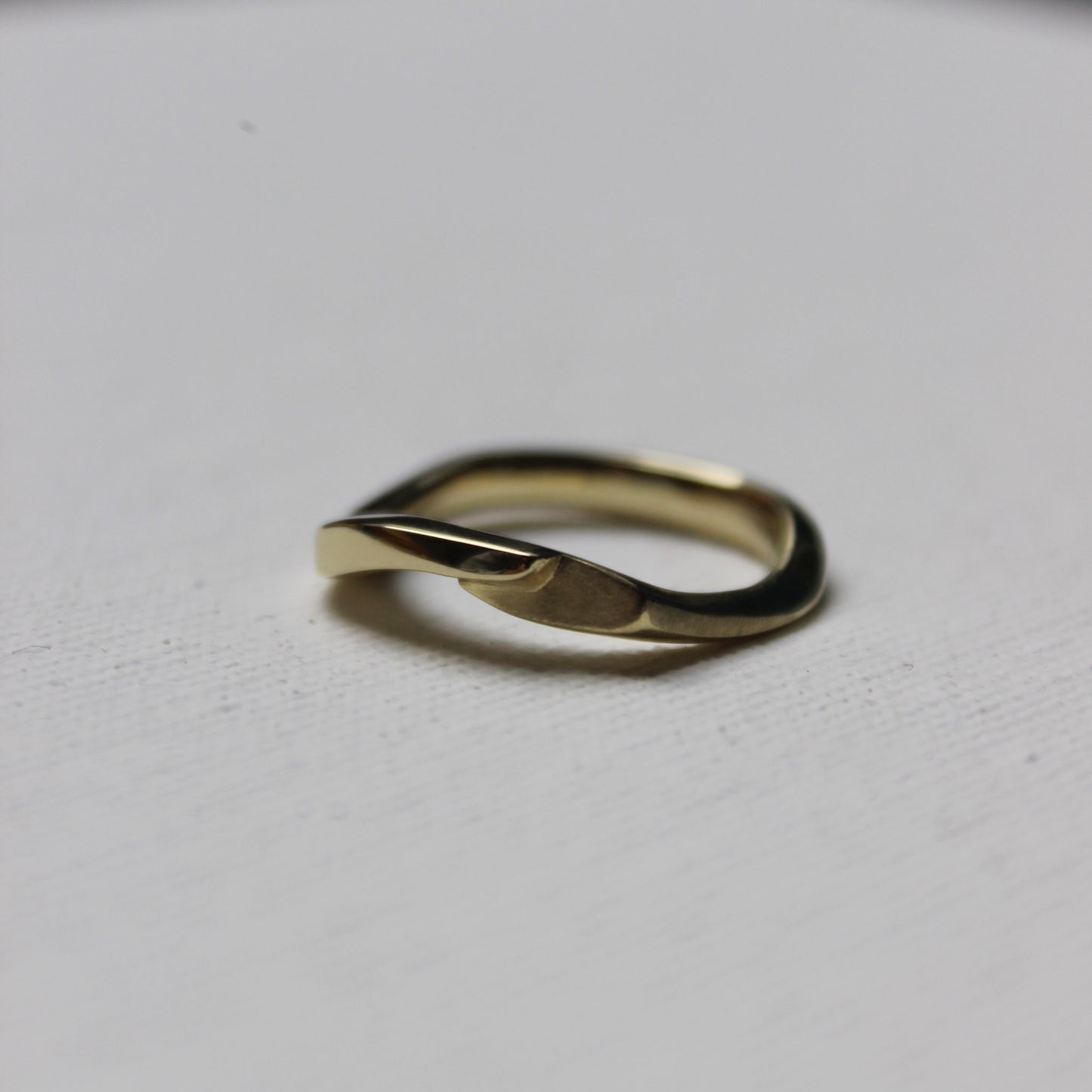 Gold ring with a unique design on a light gray background