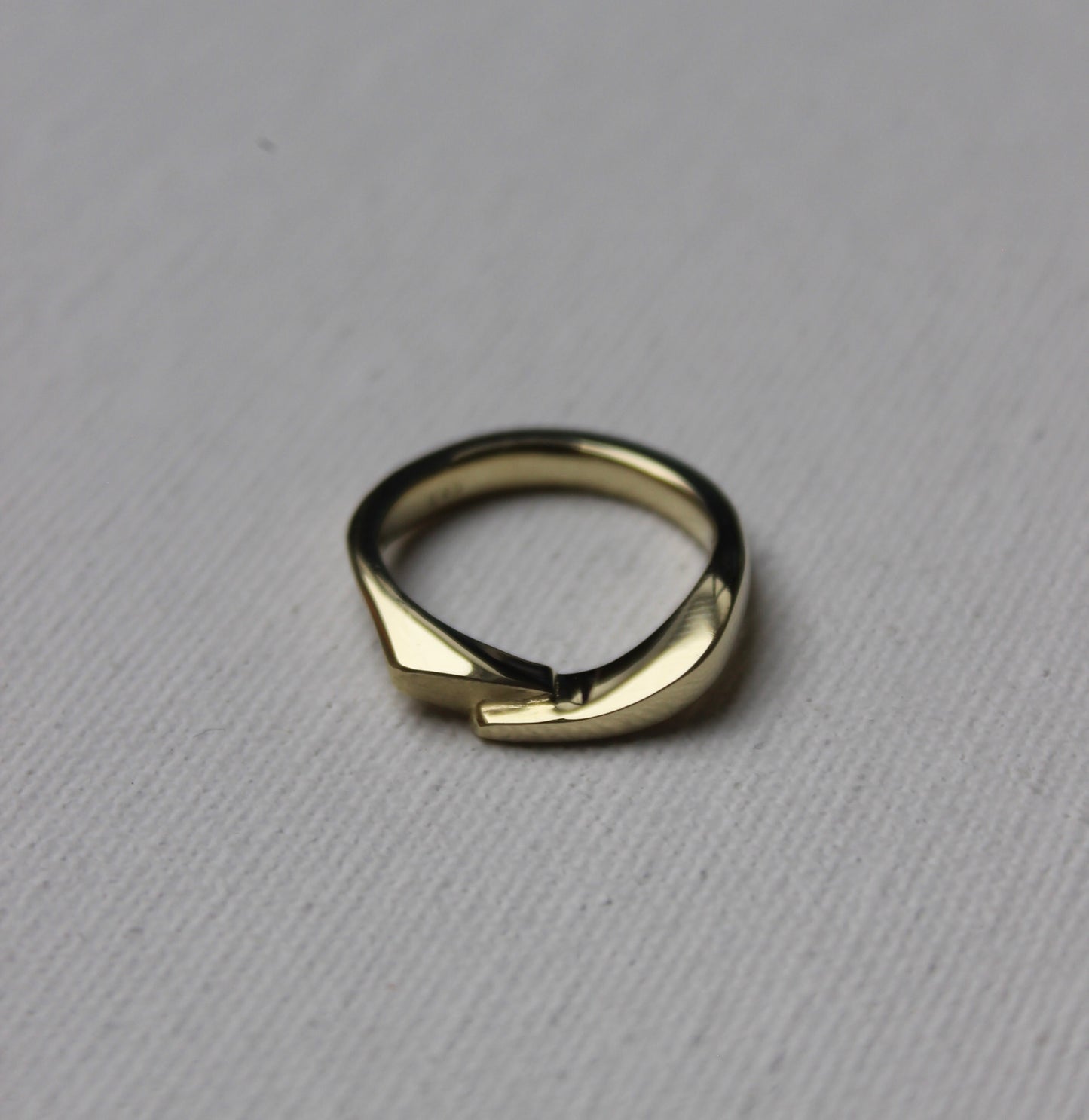Gold ring with a unique design on a gray background