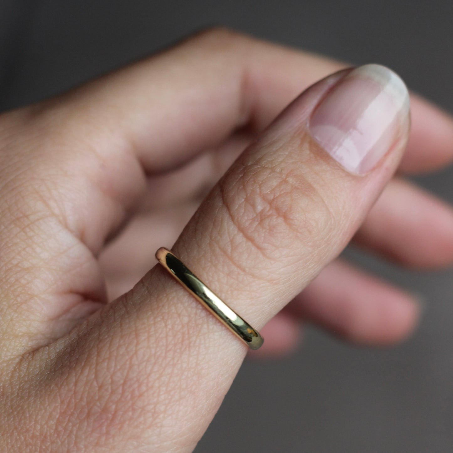 Gold ring on a finger with a blurred background