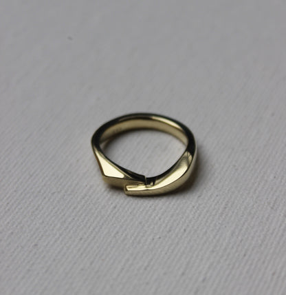 Gold ring with a unique design on a gray background